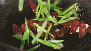 先后下香腸片、四季豆絲均勻翻炒，加適量清水燜煮一下。