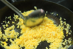 大火加熱炒鍋，再入油，燒到四至五成熱時(shí)倒入雞蛋液，在未凝結(jié)之前，加米飯煸炒，不停翻炒并用鍋鏟將成塊的米飯碾開、撥散。