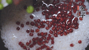 將炒好的食材和大米、紅豆一起放進(jìn)電飯鍋煮。