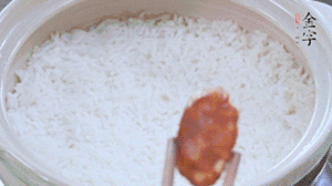 煮開后轉(zhuǎn)小火，當(dāng)米飯出現(xiàn)小孔時，鋪上金字麻辣香腸。