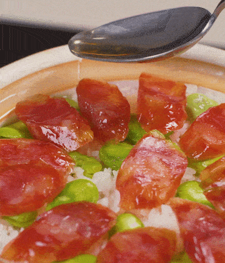 大米出現(xiàn)小孔時(shí)開蓋放香腸，往鍋邊淋入少許油，再燜煮8~10分鐘左右。