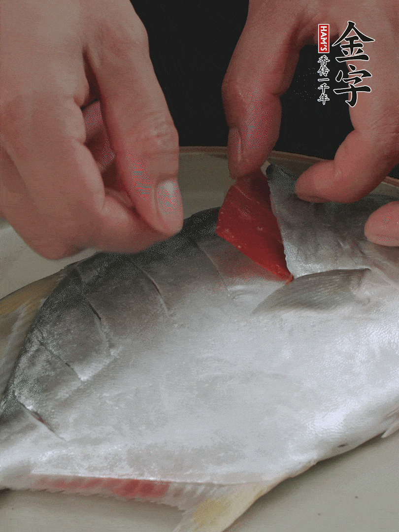 火腿片和姜片塞在刀口處，也塞一些入魚(yú)肚。