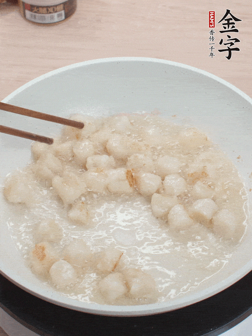 油溫4成熱，鮮貝蘸干淀粉下鍋煎，一面微黃后翻面。