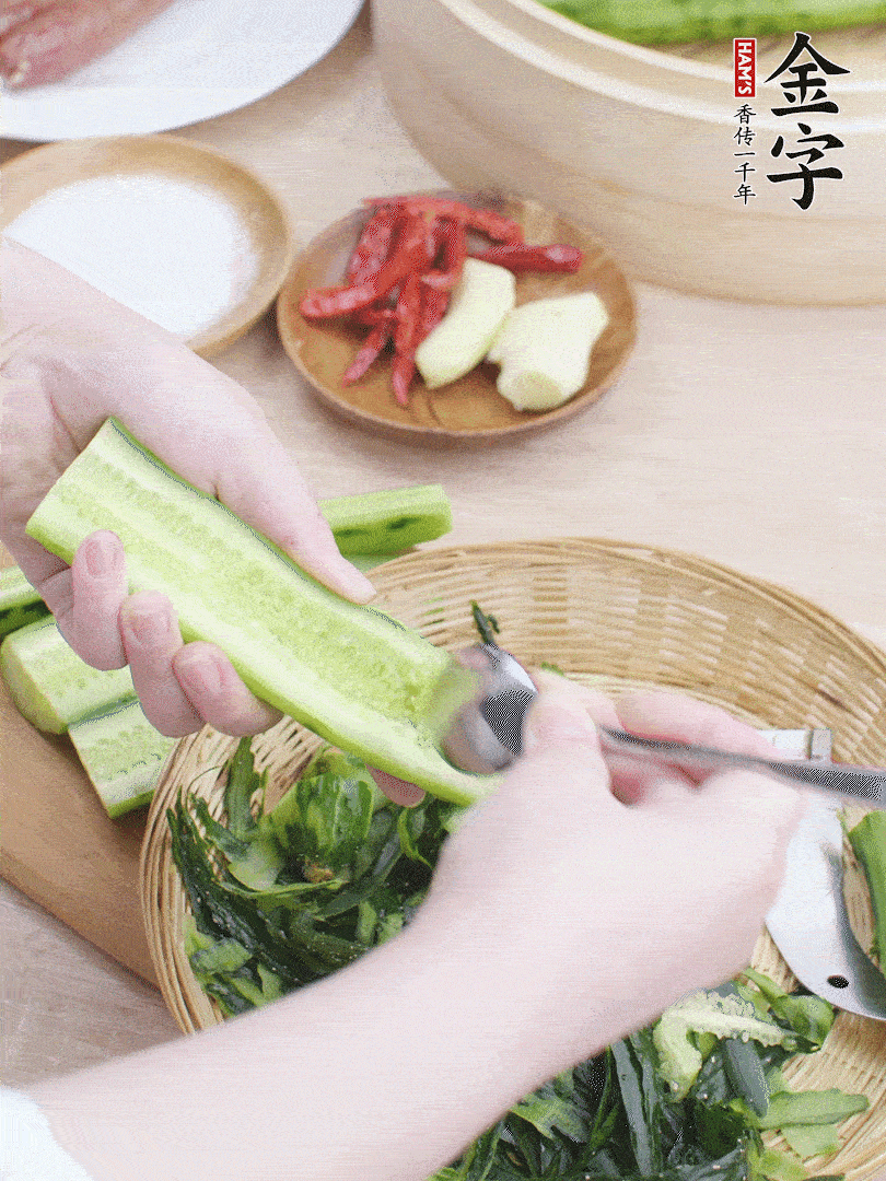 黃瓜削皮，對(duì)半切開，勺子挖去內(nèi)瓤，斜刀切片。青蒜斜刀切段。