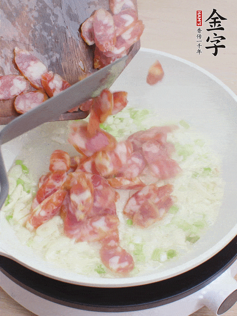 油5成熱，蒜末、蔥白爆香，下香腸炒出香味。