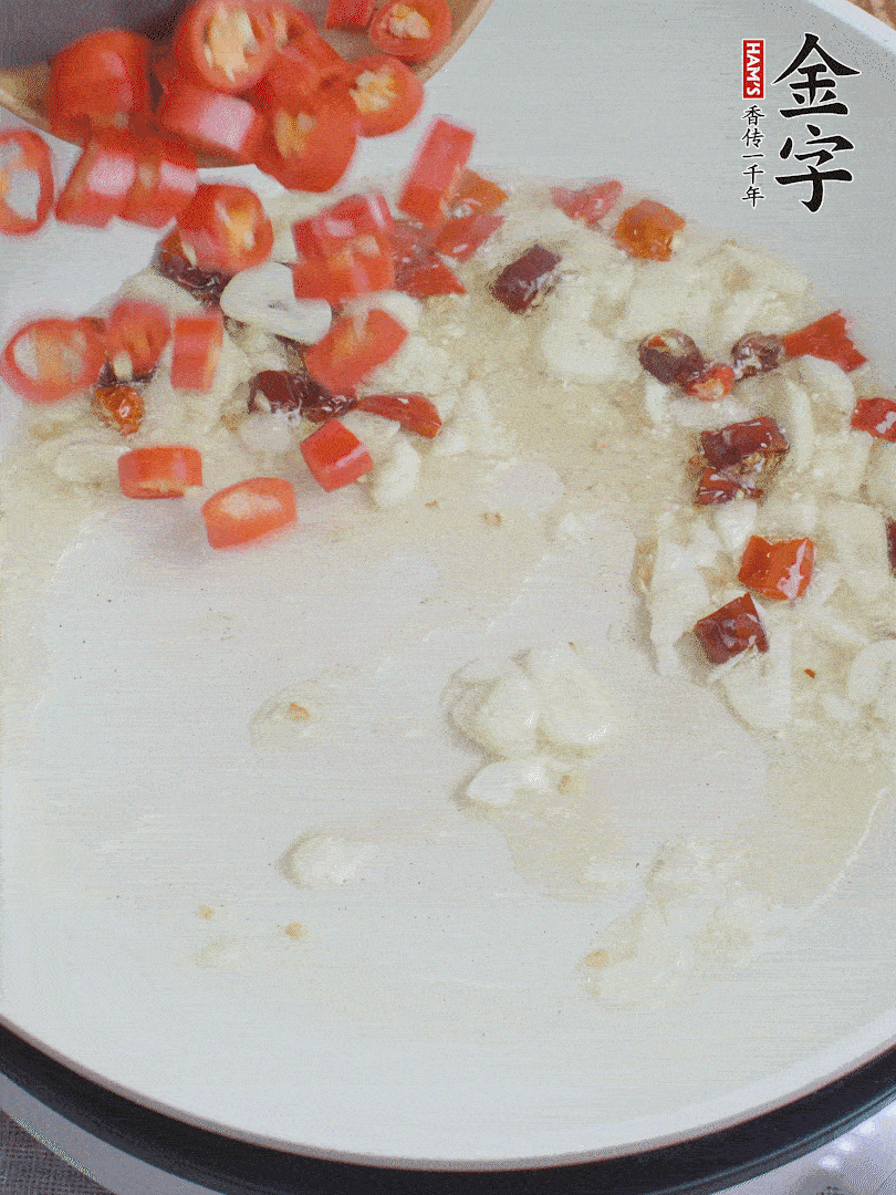 油6成熱，下蒜末、干紅辣椒煸炒，出香味后再放美人椒、香腸。