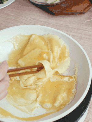 油6成熱時，下雞蛋液，邊緣凝固時翻拌成塊狀。