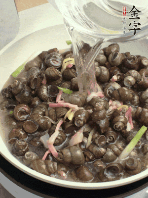 倒處理干凈的螺螄翻炒，加3勺料酒。加清水蓋過螺螄，中火蓋蓋煮5分鐘。