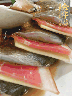 魚肚中塞蔥結(jié)、火腿片，魚身上碼放姜片、火腿片，倒入混合的料汁。