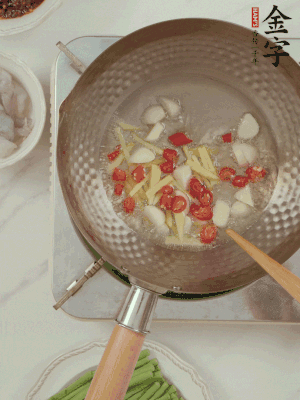 油7成熱時，下大蒜粒、姜絲、小米辣煸香。