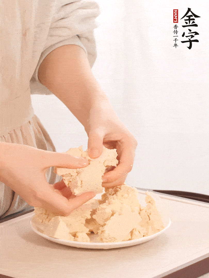老豆腐用手掰成塊。