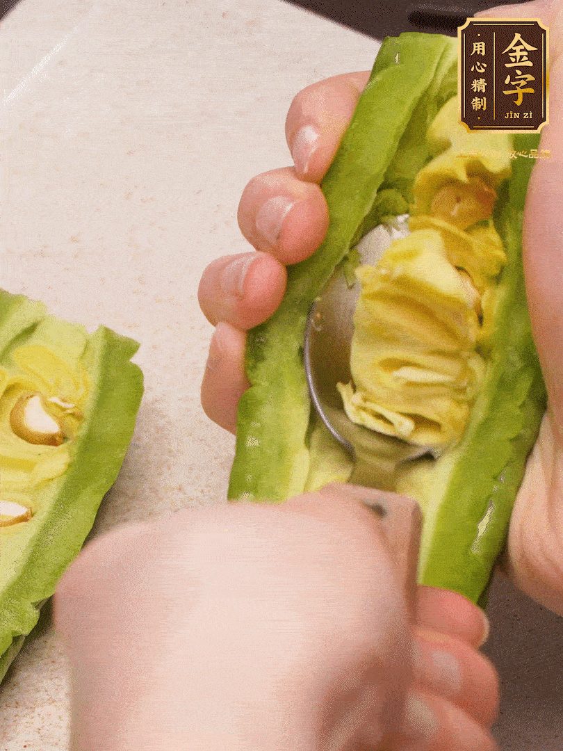 苦瓜從中間切開，把里面的瓢和籽全部挖干凈