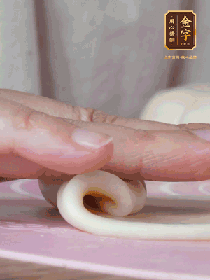 做面劑 油皮按扁，中間包入一個(gè)油酥，邊緣收緊捏死。包好的面劑按扁，用搟面杖搟壓成橢圓形。從底部向上卷成筒狀，用保鮮膜蓋好松弛15分鐘，再把筒狀縱向搟壓成長條狀。再卷一次，松弛20分鐘