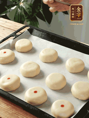 收口向下放在案板上，輕輕將月餅坯按扁，用筷子點(diǎn)紅點(diǎn)做裝飾