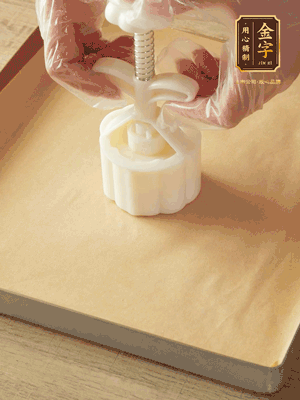 取一個(gè)面團(tuán)，捏扁，中間厚，四周薄。虎口往上推，直到收口，把餅胚放入模具里，壓2-3下