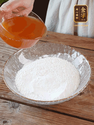 轉(zhuǎn)化糖漿、枧水、花生油攪拌均勻，加入面粉混合，醒發(fā)2小時。捏成23g一個的小球