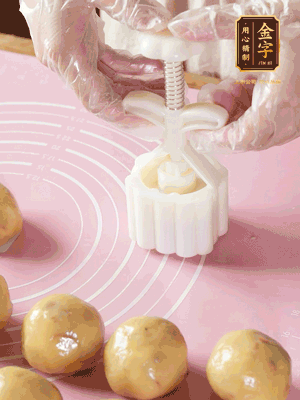 收緊虎口搓圓，裹上一層面粉，放入模具壓一壓