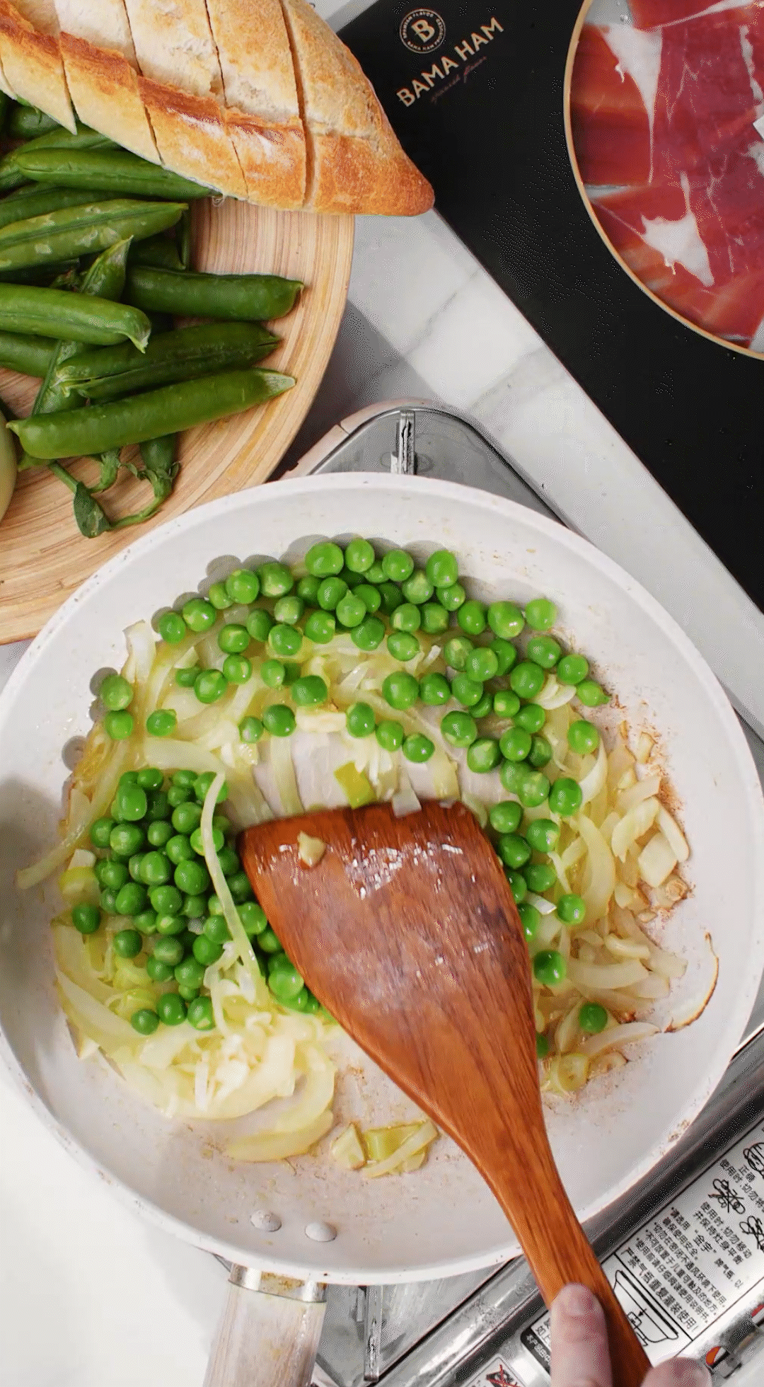 鍋中放入黃油融化，加入洋蔥絲、大蔥蔥白絲、蒜末翻炒變軟出香味。加入剛剛汆燙冰鎮(zhèn)后的豌豆，取出一點(diǎn)點(diǎn)待會(huì)擺盤(pán)裝飾用。加一點(diǎn)鹽 (和黑胡椒) 調(diào)味。