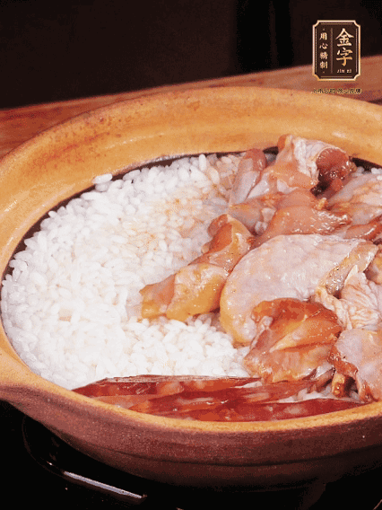 煮到椰子水微微收干轉(zhuǎn)小火，快速均勻鋪上雞肉、金字香腸