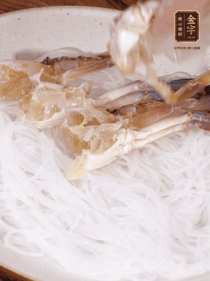 盤(pán)底墊上粉絲，擺上梭子蟹、火腿片，撒姜粒，淋上蒸魚(yú)豉油、花雕酒調(diào)味腌制15分鐘