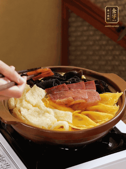 砂鍋底部鋪上娃娃菜，依次擺上肉皮、蛋餃、黑木耳、火腿